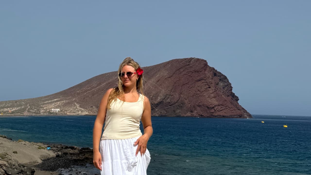 Jill mit Blume im Haar an der Küste vor der Montaña Roja auf Teneriffa